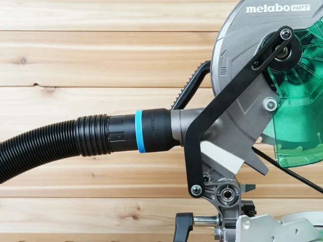 Black ToolCurve 2-1/2 inch hose adapter with blue band joining a ribbed hose to a Metabo HPT miter saw dust port
