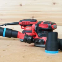 Black 36mm hose adapter with blue band connecting a green hose to a Craftsman sander, spare adapter beside it