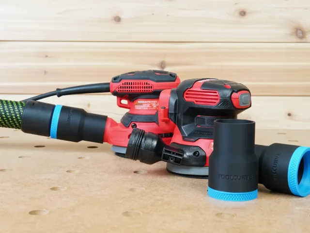 Black 36mm hose adapter with blue band connecting a green hose to a Craftsman sander, spare adapter beside it