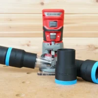 Black 36mm hose adapter with blue collar connecting a vacuum hose to a red Craftsman 20v router, plus a spare adapter