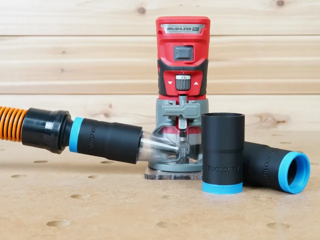 Black 1-1/4 inch hose adapter with blue collar joining an orange vacuum hose to a red Craftsman 20v router, plus two spare adapters