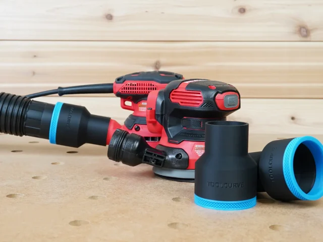 Black ToolCurve 2-1/2" hose adapter with blue trim beside a red Craftsman sander connected to a vacuum hose