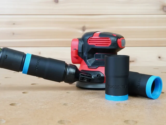 Black hose adapter with blue bands attached to Craftsman random-orbit sander dust port, showing compatible 27mm hose connections