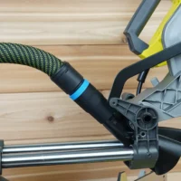Hose adapter with blue band attached to Ryobi 10-inch sliding miter saw dust port, connected to green and black hose