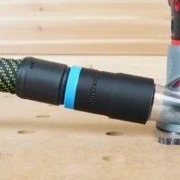 Black hose adapter with blue band attached to braided Festool hose next to Craftsman 20v router on wood workbench