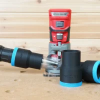 Black 1-7/8 inch hose adapter with blue trim linking a vacuum hose to a red Craftsman 20v router, plus two spare adapters