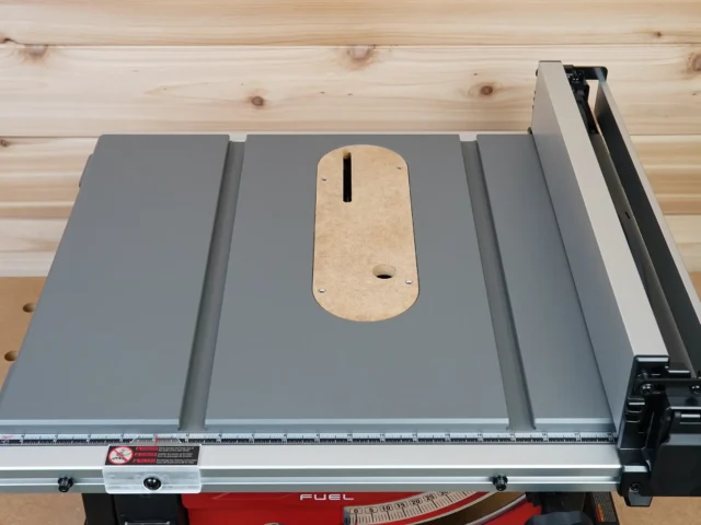 Zero clearance insert with natural MDF face installed on Milwaukee M18 table saw, showing centered slot and mounting hole