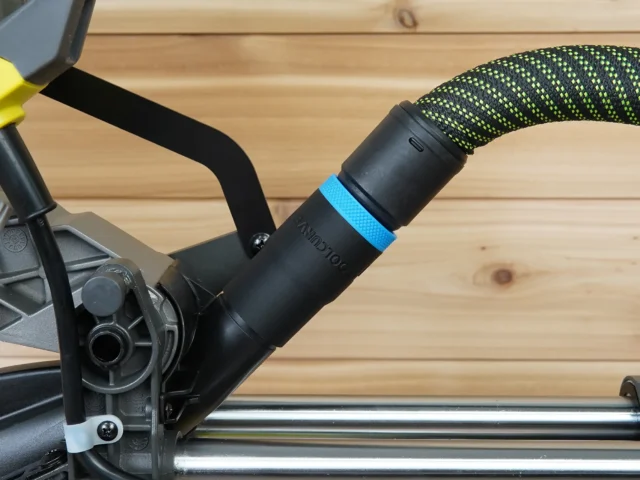 Black hose adapter with blue band attached to Ryobi 10-inch miter saw dust port, connected to green and black braided hose