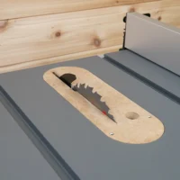 MDF zero clearance insert installed flush in a gray Milwaukee M18 table saw table with blade raised through the slot