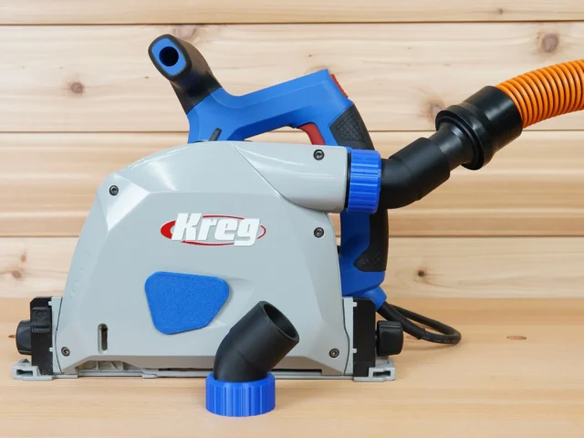 No Snag Dust Port attached to a Kreg track saw, with orange hose angled upward and away from the saw body