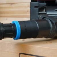 Black 1-7/8 inch hose adapter with blue ring joining a vacuum hose to a Porter Cable benchtop sander dust port