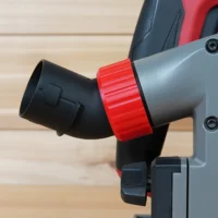 No Snag Dust Port for Milwaukee Track Saw mounted on tool, with red knurled collar and black angled elbow showing upward hose routing