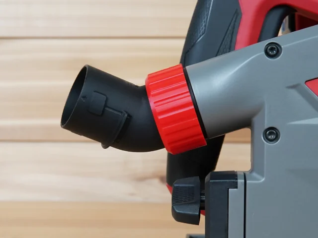 No Snag Dust Port for Milwaukee Track Saw mounted on tool, with red knurled collar and black angled elbow showing upward hose routing