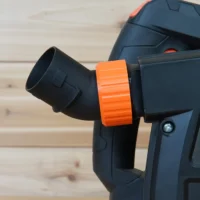 Black no snag dust port adapter with bright orange quick-change collar attached to a Wen track saw, angled upward away from the tool