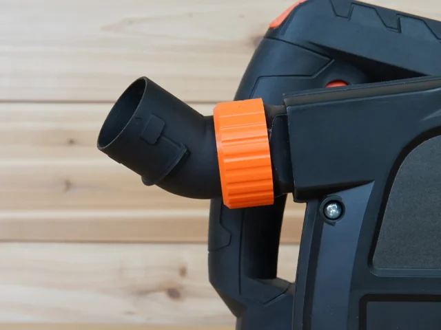 Black no snag dust port adapter with bright orange quick-change collar attached to a Wen track saw, angled upward away from the tool