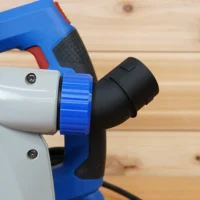 Blue and white no snag dust port adapter attached to a Kreg track saw, with black hose connection angled upward