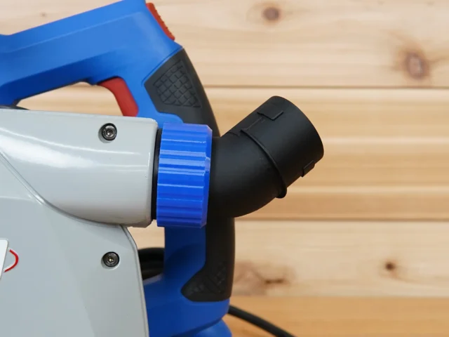 Blue and white no snag dust port adapter attached to a Kreg track saw, with black hose connection angled upward