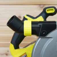 Black and yellow no snag dust port adapter installed on a Ryobi track saw, with bright yellow hose collar and upward-angled port visible
