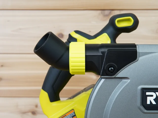 Black and yellow no snag dust port adapter installed on a Ryobi track saw, with bright yellow hose collar and upward-angled port visible