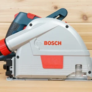 Bosch GKT13 corded track saw shown from the side with a red arbor cover fitted flush on the blade housing