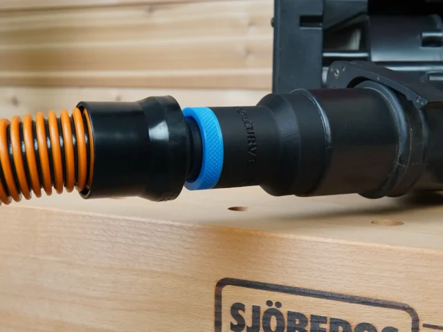 Black 1-1/4 inch hose adapter with blue collar joining an orange vac hose to a Porter Cable sander dust port