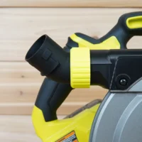 Black and neon-yellow dust port adapter mounted on a Ryobi track saw, with hose collar angled upward and away from the tool