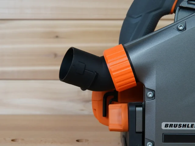 No Snag Dust Port for Ridgid Track Saw attached to gray track saw body, orange adapter angled upward with black hose connector