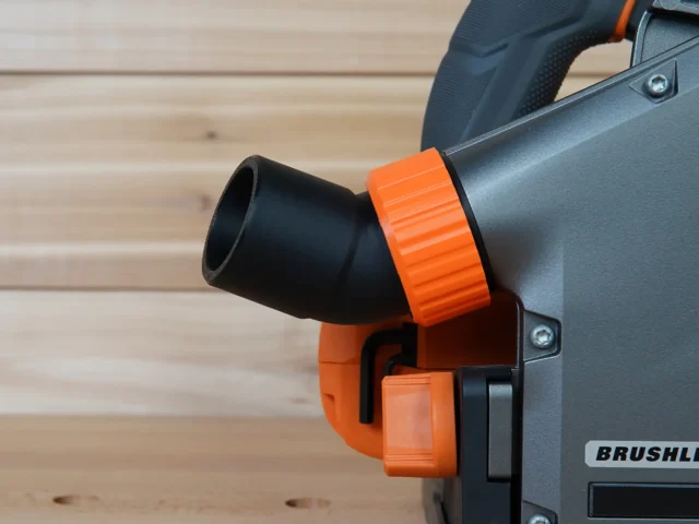 Black and orange no-snag dust port adapter attached to a Ridgid track saw, with hose angled upward away from the tool