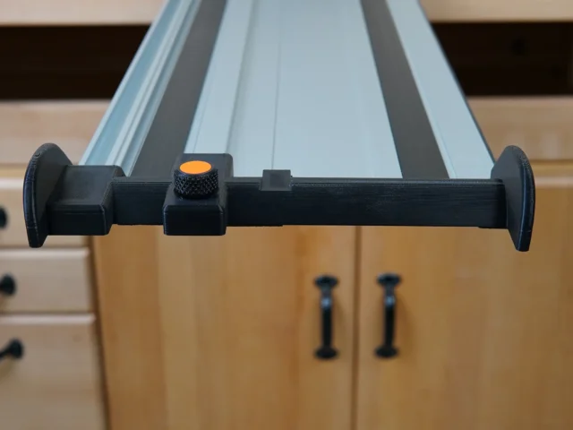 Black hose deflector mounted on PowerTec guide rail with orange quick-release knob and dual clamping handles