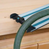 Black hose deflector mounted on Makita track saw guide rails, guiding green and black braided hose away from the cutting path