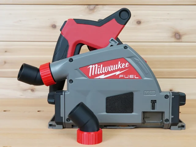 No Snag Dust Port for Milwaukee track saw mounted on a Milwaukee M18 track saw, angling the hose upward with red and black plastic components
