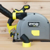 ToolCurve no snag dust port adapter attached to a Ryobi track saw, with hose routed upward and away from the cutting area