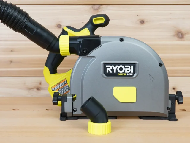 ToolCurve no snag dust port adapter attached to a Ryobi track saw, with hose routed upward and away from the cutting area