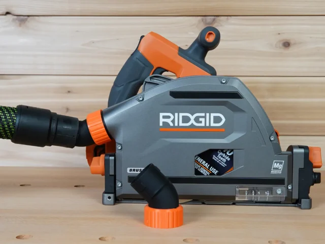 No snag dust port adapter attached to a Ridgid track saw, showing the angled hose connection and quick-change port design