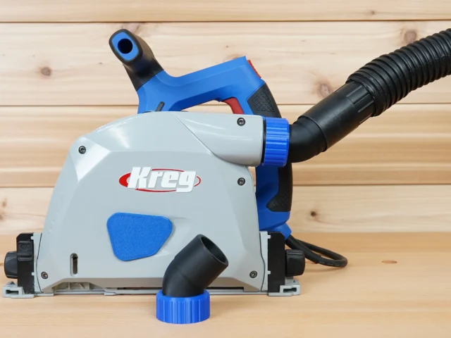 No Snag Dust Port for Kreg track saw mounted on blue Kreg saw, with black hose attached upward and angled away from tool