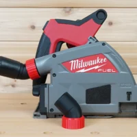 No Snag Dust Port for Milwaukee track saw, gray and red adapter with black hose attached, mounted on Milwaukee Fuel track saw