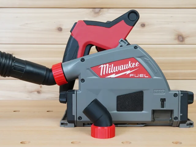 No Snag Dust Port for Milwaukee track saw, gray and red adapter with black hose attached, mounted on Milwaukee Fuel track saw