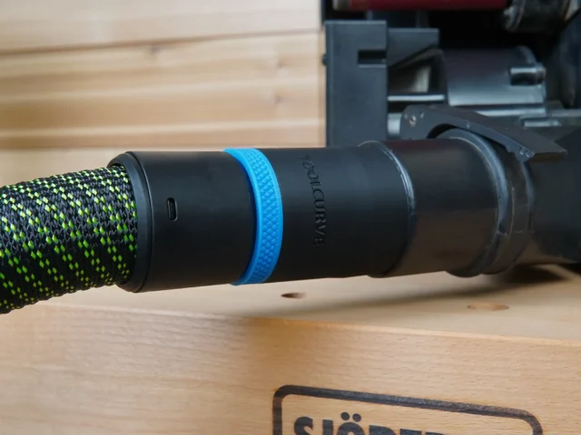Black 36mm hose adapter with blue ring joining a green vacuum hose to a Porter Cable benchtop sander dust port