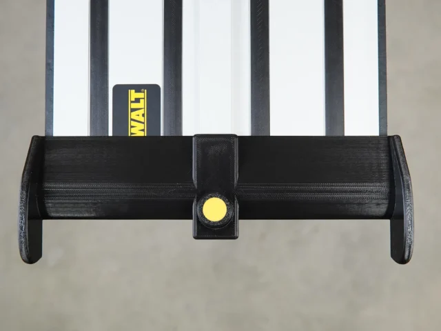 Black plastic hose deflector with yellow clamping knob, mounted on a DeWalt guide rail system