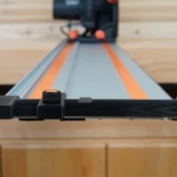 Black hose deflector with textured knob mounted on a Wen guide rail, front view