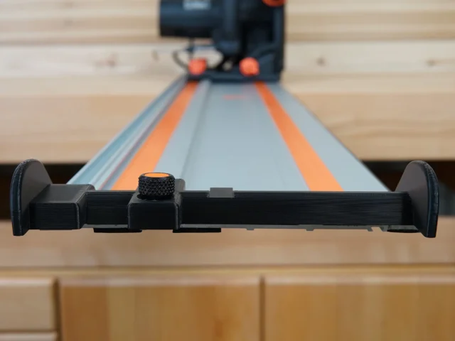 Black hose deflector with textured knob mounted on a Wen guide rail, front view