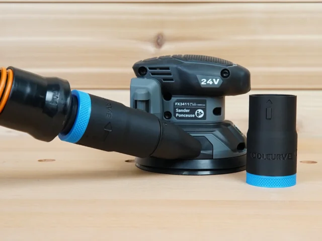 Black 1-1/4 inch hose adapter with blue collar beside a Flex sander, second adapter joining orange hose