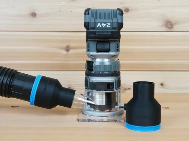 Black 2-1/2 inch hose adapter with blue trim standing beside a FLEX 24v router, second adapter joined to a vacuum hose at the router's dust port