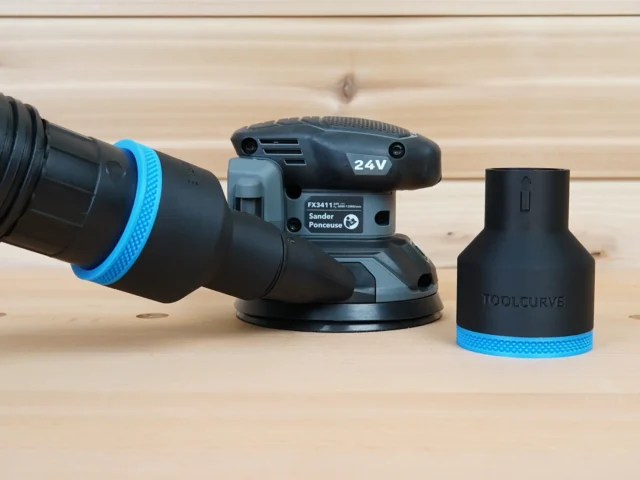 Black 2-1/2 inch hose adapter with blue ring standing beside a Flex FX3411 sander and vacuum hose