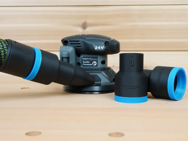 Black 36mm ToolCurve hose adapter with blue trim beside a Flex 24V sander and dust extractor hose