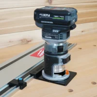 FLEX 24v router attached to guide rail adapter on Festool track saw rail, with orange latch visible on black mounting base