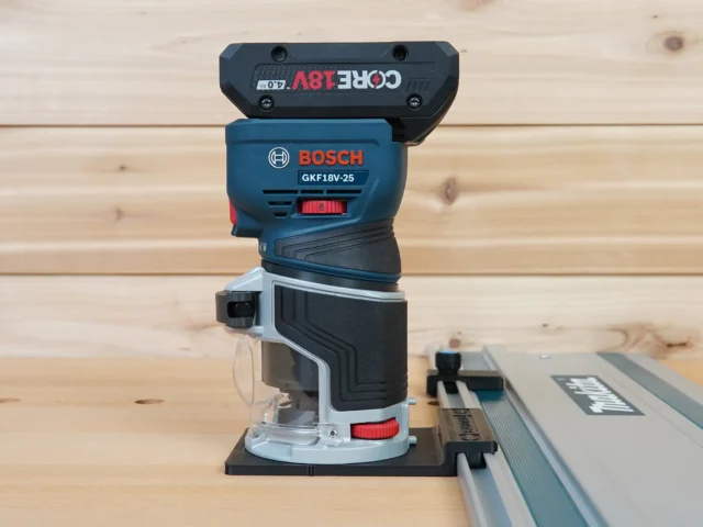 ToolCurve guide rail adapter mounted on a Bosch GFK18v Colt router, connected to a guide rail track on wooden surface