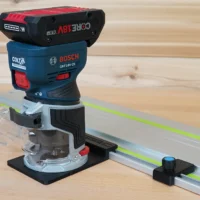 Bosch GFK 18v Colt router mounted on guide rail adapter, positioned on Festool track with green laser line visible