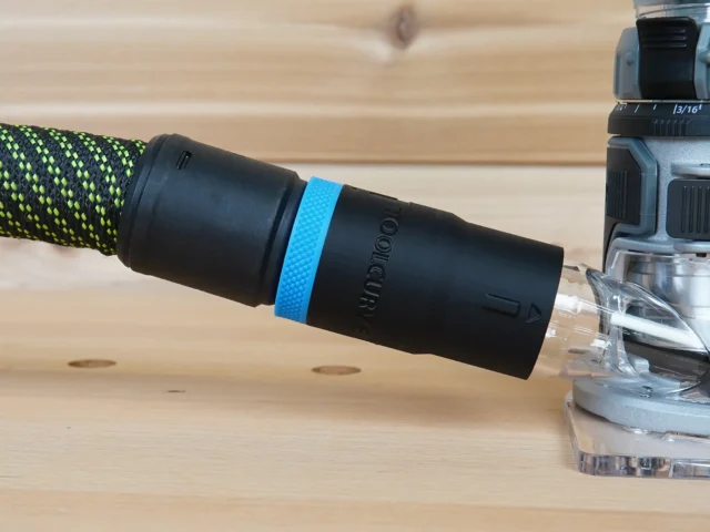 Black hose adapter with blue band attached to green and black braided hose, connected to FLEX 24v router dust port