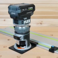 FLEX 24V router mounted on black adapter base, positioned on aluminum guide rail with green laser line